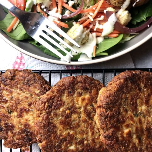salmon cakes on wire rack with salad on the side
