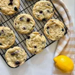 blueberry lemon cookies on cooling rack with lemon and yellow striped towel
